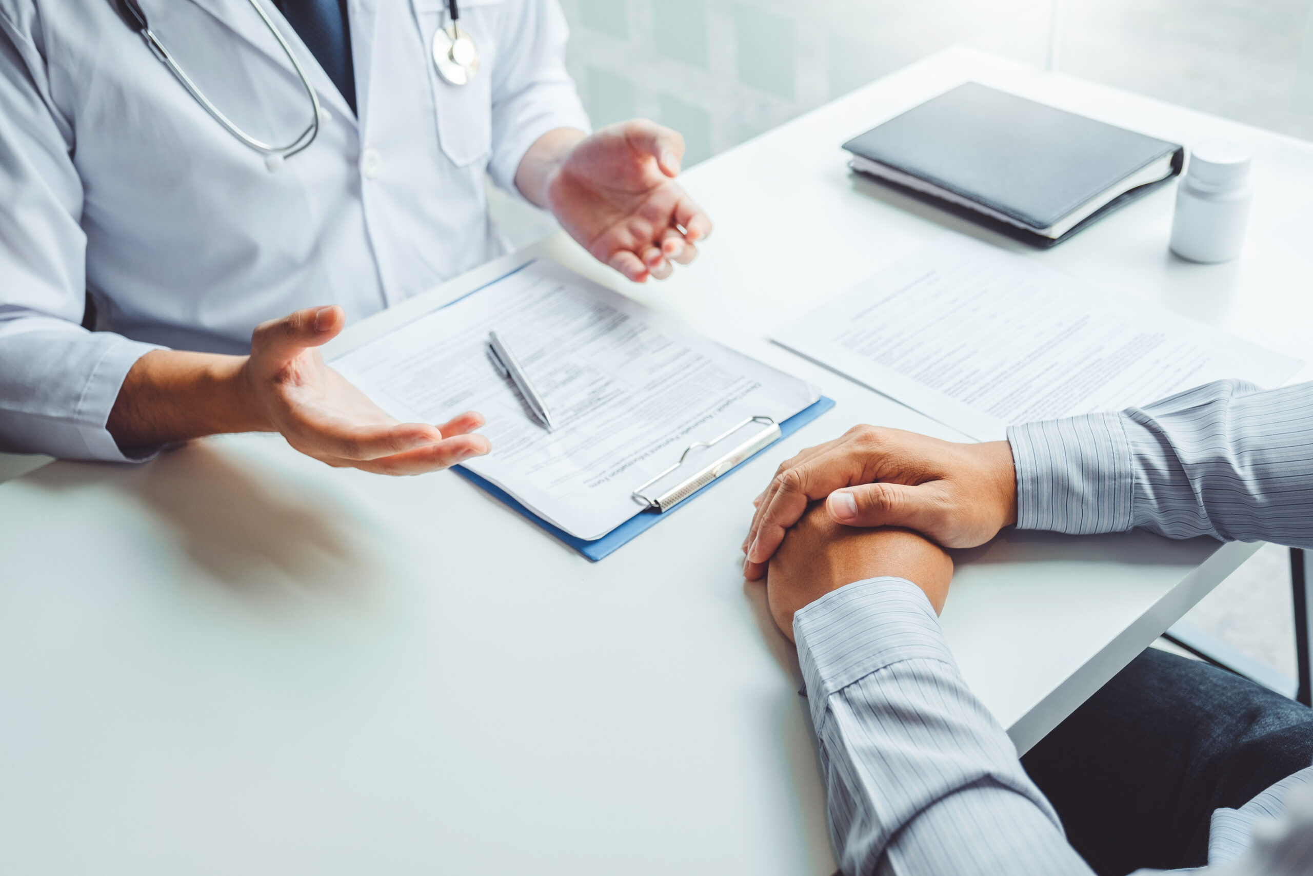 Doctors and patients consulting and diagnostic examining sit and talk. At the table near the window in the hospital medicine concept